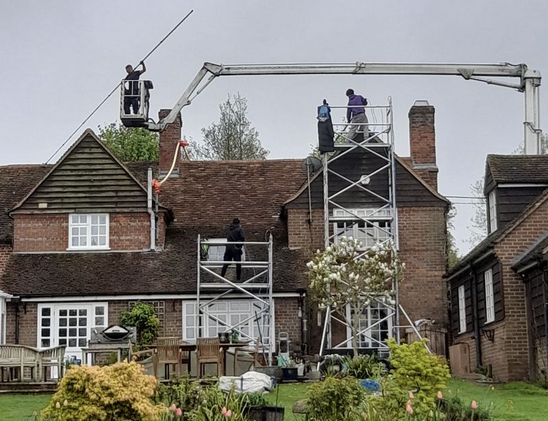 The Moss Cleaners using cherry picker and scaffolding to clean roof safely and professionally in Walton-on-Thames, Surrey